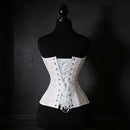 White corset on a black mannequin against a dark background, Obroi