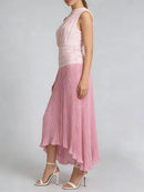 Woman wearing a pink pleated dress on a plain background, Obroi