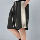 Black shorts with white stripes worn by a person on a gray background, featuring the brand 'Obroi'.
