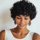 Woman with styled black hair wearing a white top against a plain background, Obroi