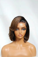 A medium brown wig with dark brown root accents and side parts, styled in a shoulder-length bob with soft waves, displayed on a mannequin head against a light gray background, Obroi
