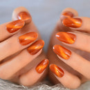 Close-up of hands with orange and red marbled nail polish on a neutral background, Obroi