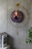 Decorative wall clock with gold frame and unique design on a concrete wall, Obroi