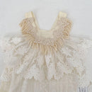 A cream-colored toddler dress featuring a textured lace bodice with ribbon straps, layered with ruffled tulle and floral lace overlays, Obroi