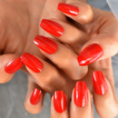 Close-up of hands with bright red nail polish on a neutral background, Obroi