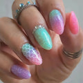 Close-up of a hand with multicolored glittery nail art on a neutral background, Obroi