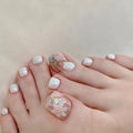 Close-up of toes with white nail polish and glittery decorations on a light background, Obroi