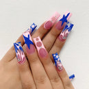 Hand with pink and blue nail art on a light gray background