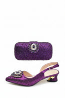Purple shoe and matching handbag set with decorative elements on a white background, Obroi