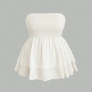 White strapless dress with smocked bodice on a gray background
