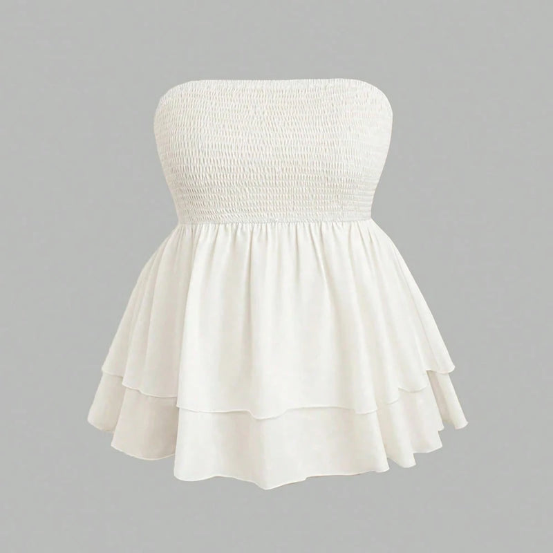 White strapless dress with smocked bodice on a gray background
