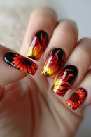 Nails with sunflower design in red, yellow, and black on a neutral background, Obroi