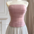 Mannequin wearing a strapless pink top and white skirt against a neutral background, Obroi