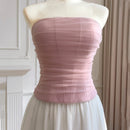 Mannequin wearing a strapless pink top and white skirt against a neutral background, Obroi