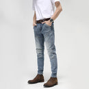 Person wearing light blue jeans with a white background, Obroi
