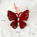 Red butterfly ornament with gold accents and a rhinestone on a white background, Obroi