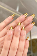 Close-up of hands with gold-accented nails against a blurred natural background, Obroi