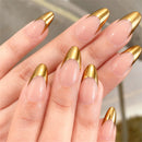 Close-up of hands with gold-accented nails against a blurred natural background, Obroi