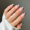 Hand with pink and silver nail polish on a neutral background, Obroi