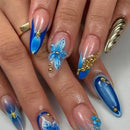 Nails with blue and gold design on a white background, Obroi.