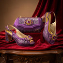 Purple high-heeled shoes and matching handbag with gemstone embellishments on a red fabric background, Obroi