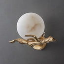 Wall sconce with marble globe and gold branch-like fixture on a dark background, Obroi