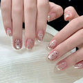 Close-up of hands with decorative nail art on a white surface, Obroi