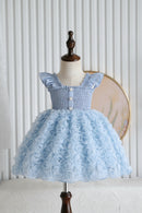 Light blue dress with floral skirt on a mannequin against a white wall, Obroi