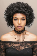 Woman with styled hair wearing a black lace top against a beige background, Obroi