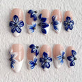 Nail art with blue floral designs on a textured white background