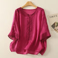 Pink blouse with lace details on a hanger against a beige background, Obroi