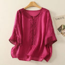 Pink blouse with lace details on a hanger against a beige background, Obroi