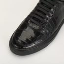 Black crocodile-patterned sneaker on a light gray background, Obroi