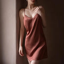 Woman wearing a pink slip dress against a plain wall, Obroi