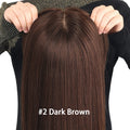 Dark brown hair extension held up by hands on a white background with '#2 Dark Brown' label, Obroi