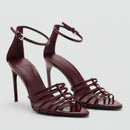 Pair of maroon high-heeled sandals with strappy design on a light gray background, Obroi