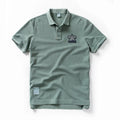 Green polo shirt with a logo on a white background, Obroi