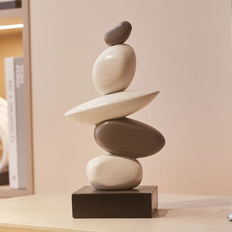 Stack of balanced stones on a wooden base against a neutral background, Obroi