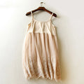 Beige lace dress on a wooden hanger against a white wall, Obroi