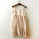 Beige lace dress on a wooden hanger against a white wall, Obroi