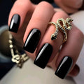 Hand with black nail polish and a gold ring on a blurred background, Obroi