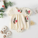 Baby romper with floral embroidery on a white background, Obroi