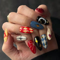 Hand with intricately designed nails featuring various patterns and colors, Obroi