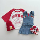 Children's clothing set with red and white shirt, denim overalls, red beanie, and red shoes on a light gray background, Obroi