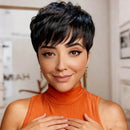 Woman with short black hair wearing an orange top indoors, Obroi