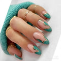 Obroi Hand with teal and pink nails with gold accents, wearing gold rings, on a white background.