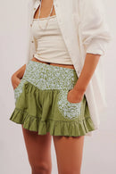 Green floral skirt worn by a person on a plain background, Obroi
