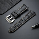 Black leather watch strap with silver buckle on a dark surface, Obroi