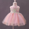 A pink children's party dress displayed on a white mannequin against a dark gray background. The dress features a sleeveless bodice with floral lace applique and a layered, fluffy tulle skirt, Obroi