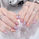 Close-up of hands with pink and purple nail polish and star designs, wearing silver rings, Obroi